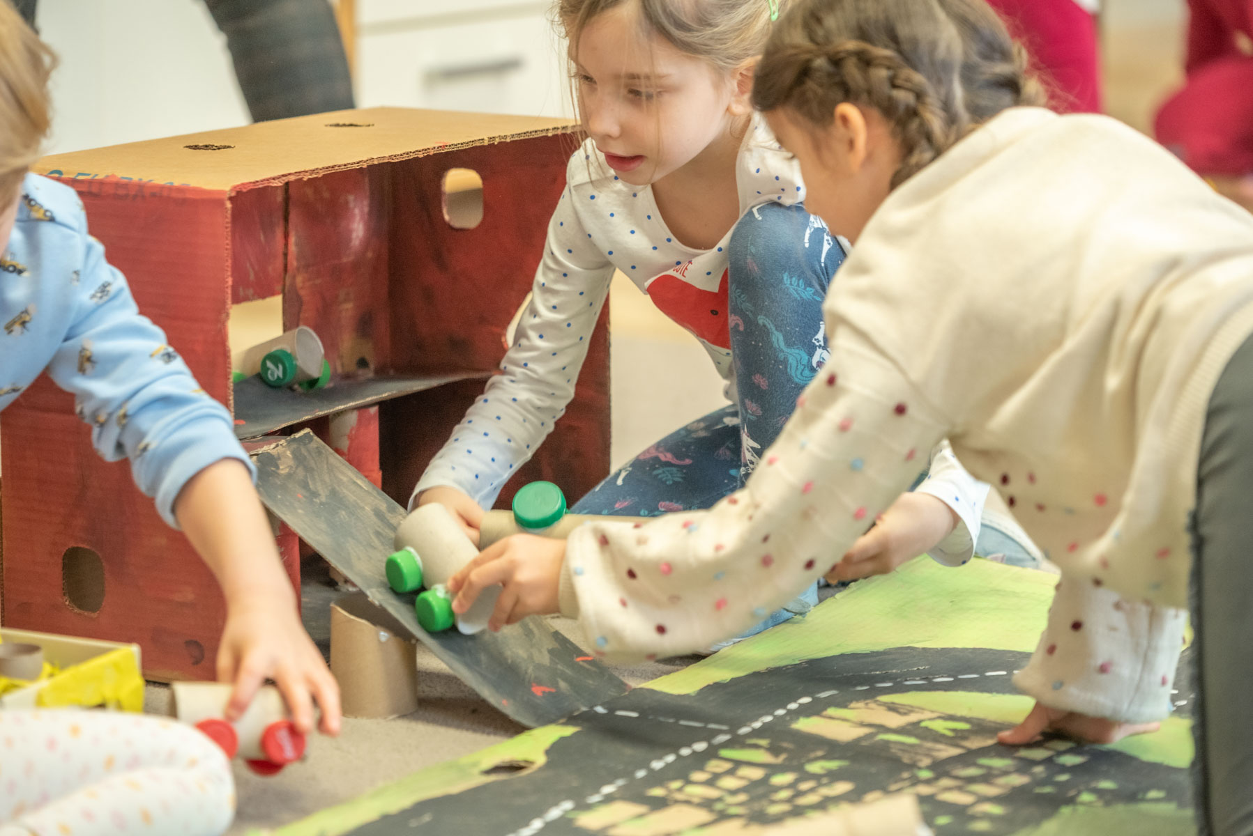 Dzieci w przedszkolu bawią się autami